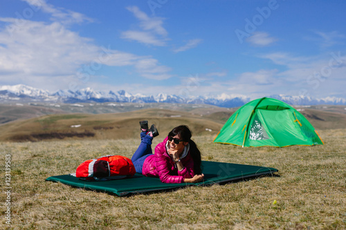 Girl lying on the rug amid the tents