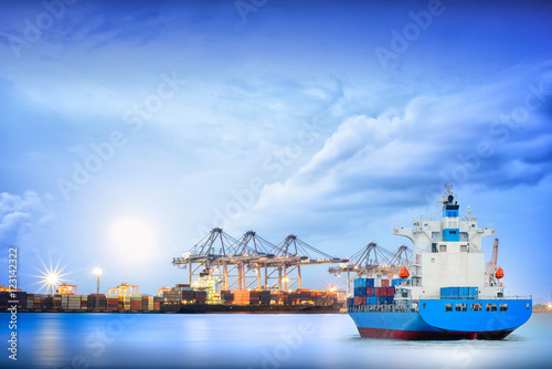 Logistics and transportation of International Container Cargo ship ship with ports crane bridge in harbor for logistics import export background and transportation industry.