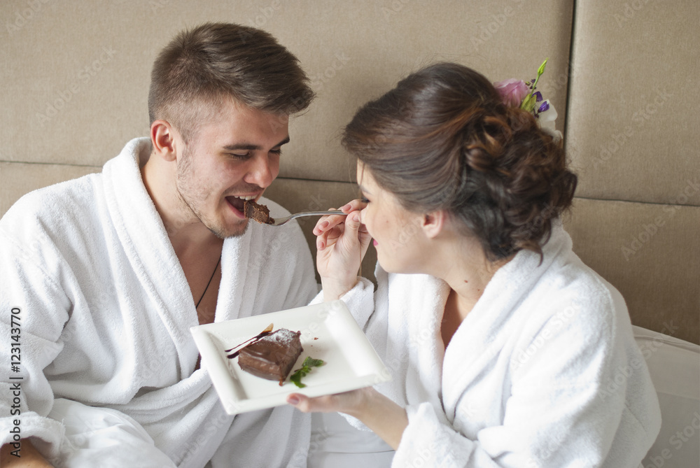 Beautiful young couple having breakfast in bed. Beautiful young couple having breakfast in bed.