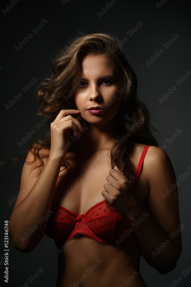 Erotica. Sexy woman in red bra looking at camera