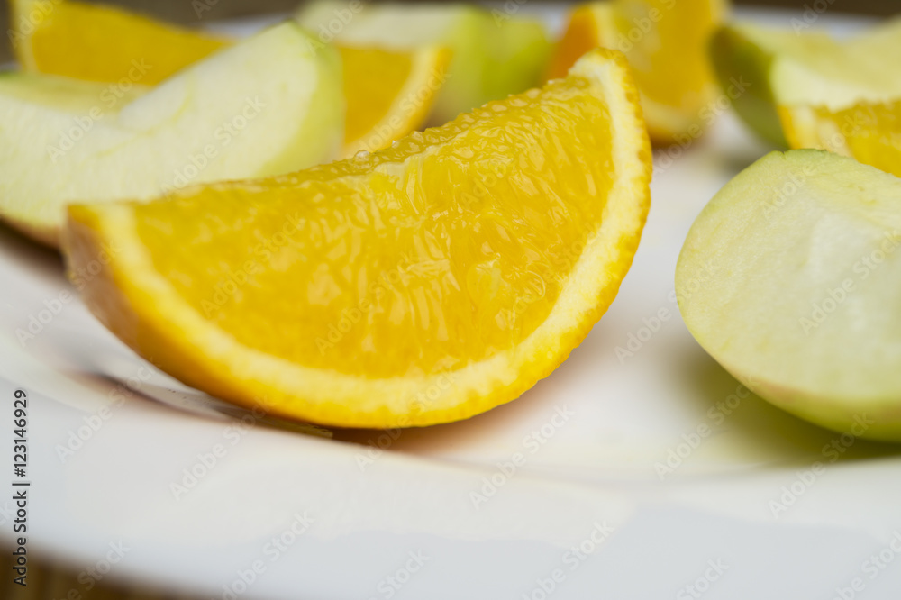 Halbierte Orangen und Äpfel auf Teller Halbierte Orangen und Äpfel auf Teller