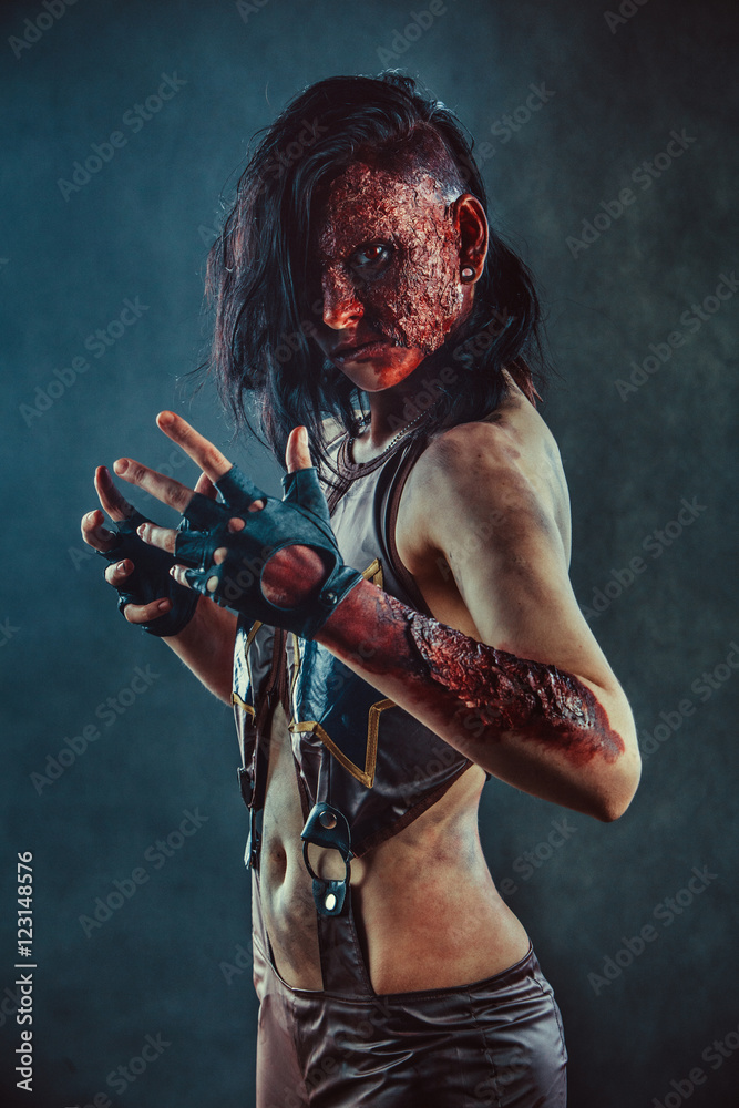 Zombie woman with the blood on the face and hands.