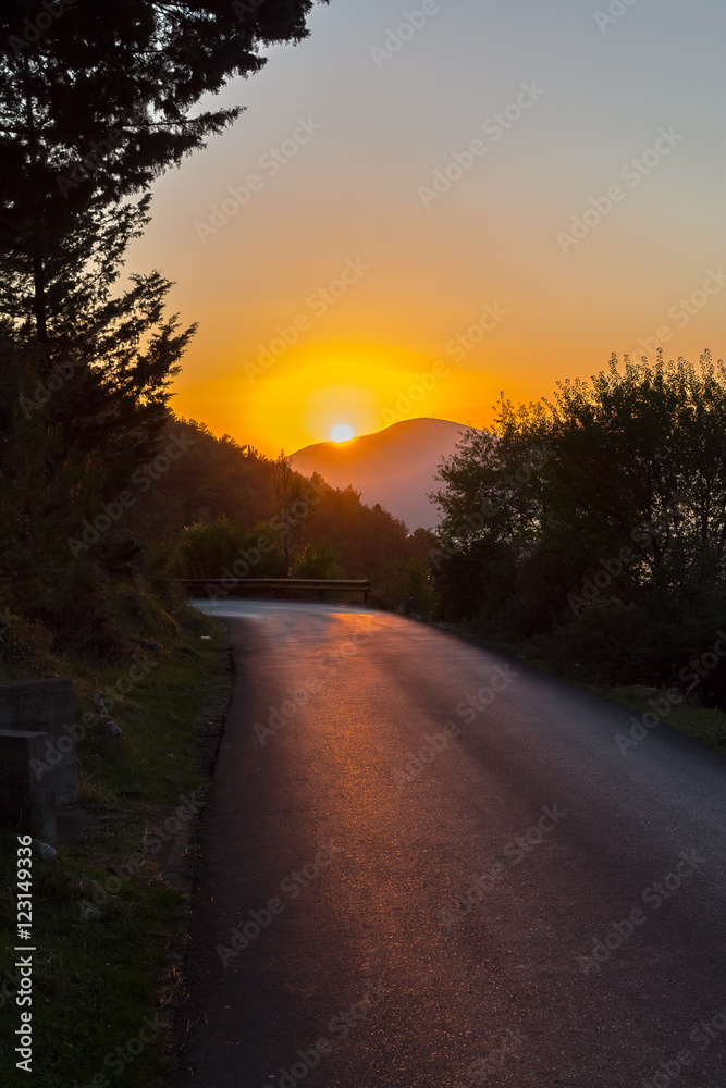 Turning asphalt road in the mountains at sunset