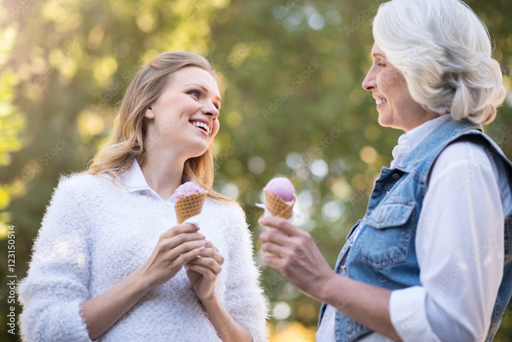 Fototapeta premium Two happy woman laughing and eating ice cream.