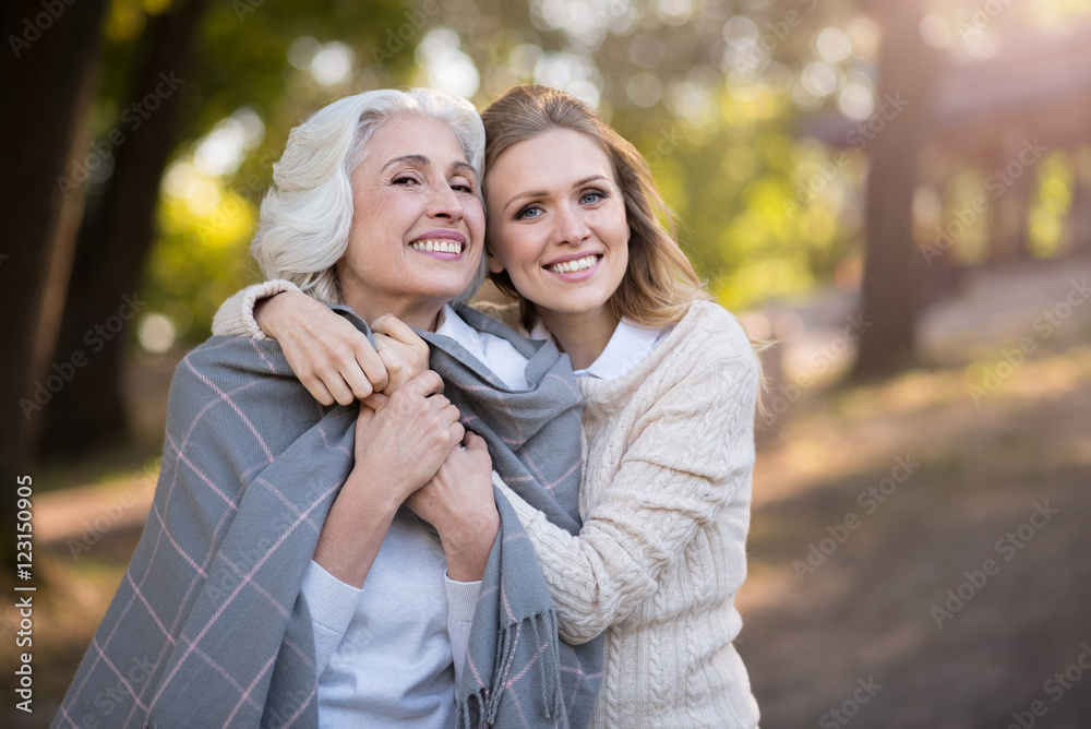 Two cheerful beautiful women smiling and hugging.