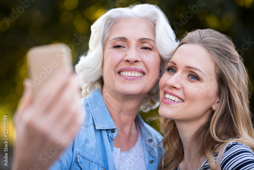 Two charming smiling women taking selfie. photo