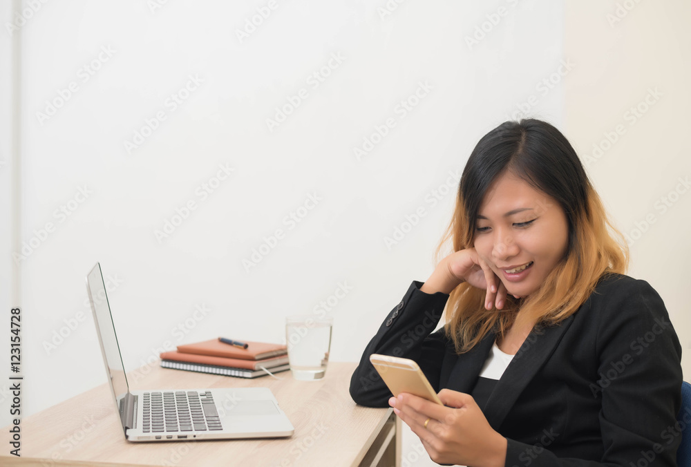 young business woman working on his laptop and using smart phone young business woman working on his laptop and using smart phone
