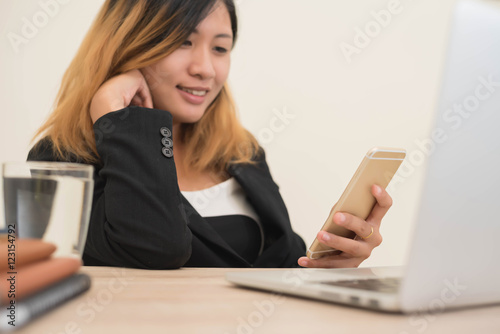 young business woman working on his laptop and using smart phone