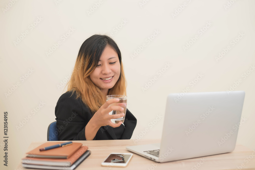 business woman working on his laptop and drinking water. business woman working on his laptop and drinking water.