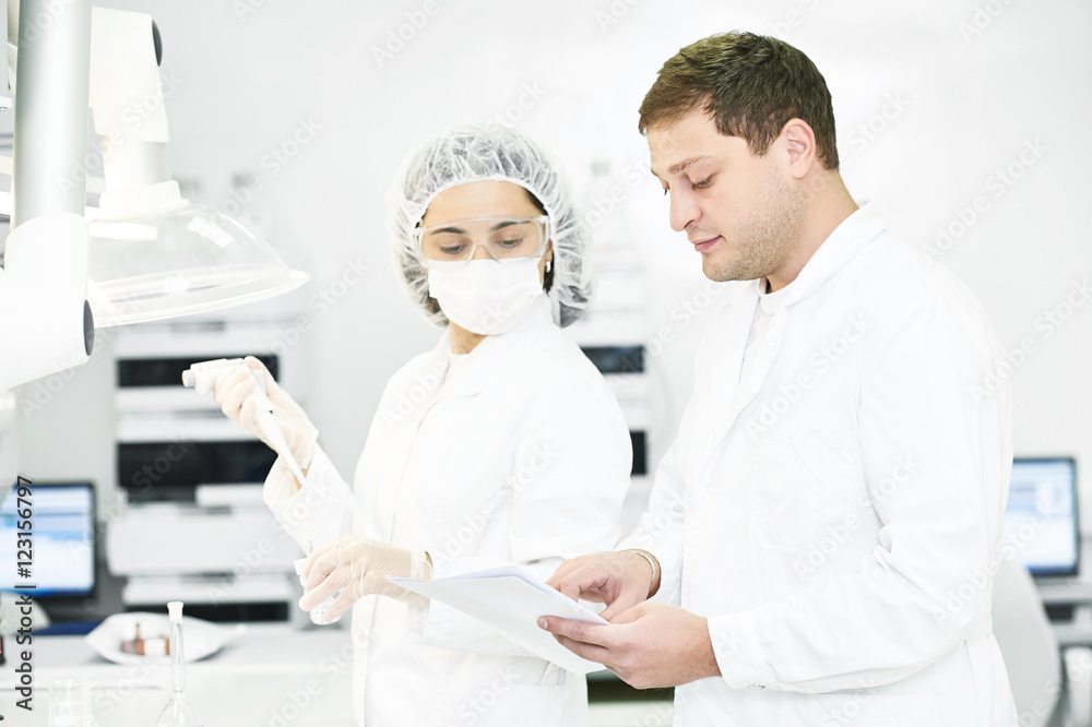 Pharmaceutical staff workers in uniform at laboratory Pharmaceutical staff workers in uniform at laboratory