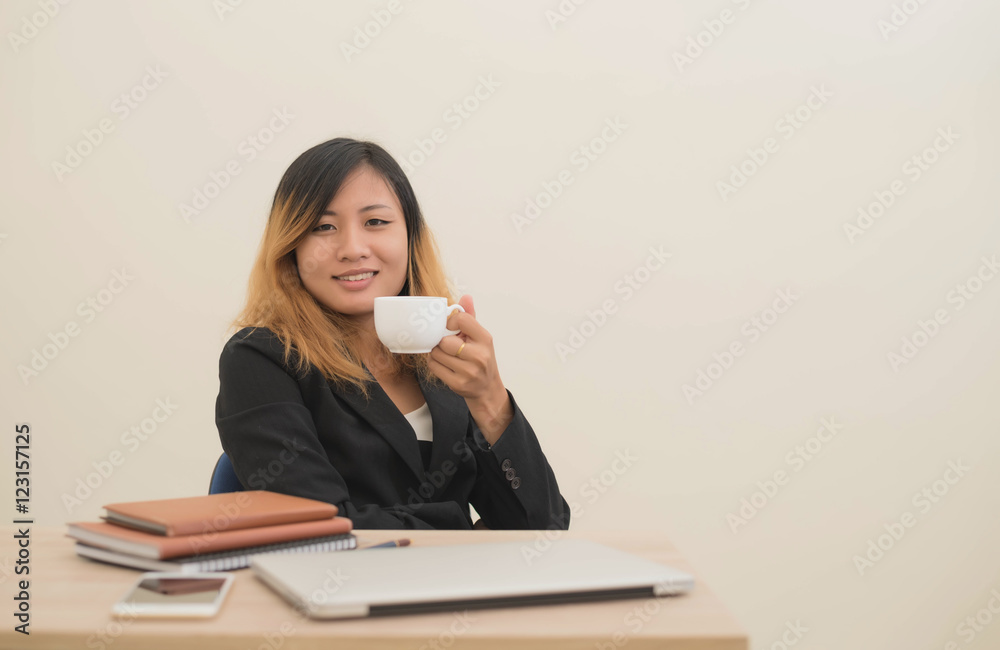 Businesswoman drinking coffee working on his laptop on the desk Businesswoman drinking coffee working on his laptop on the desk