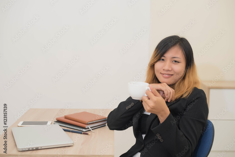 Businesswoman drinking coffee working on his laptop on the desk Businesswoman drinking coffee working on his laptop on the desk