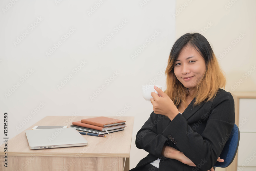 Businesswoman drinking coffee working on his laptop on the desk Businesswoman drinking coffee working on his laptop on the desk
