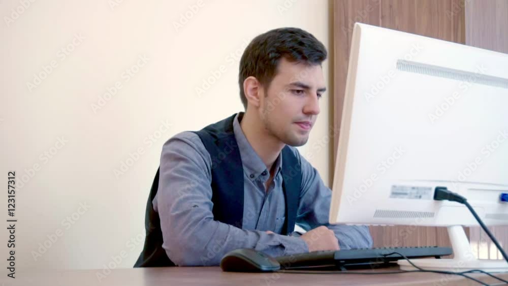 Man typing at the computer and reading the answer Man typing at the computer and reading the answer