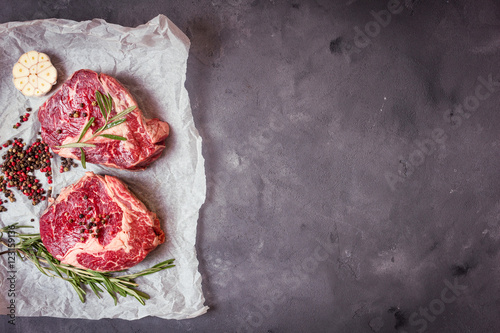 Raw meat steak on rustic concrete background ready to roasting