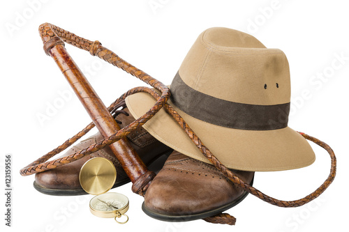 Travel and adventure concept. Vintage brown shoes with fedora hat, bullwhip and compass isolated photo