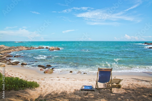 Simple chair on sandy beach by Indian Ocean on a beach in Sri Lanka, Asia.