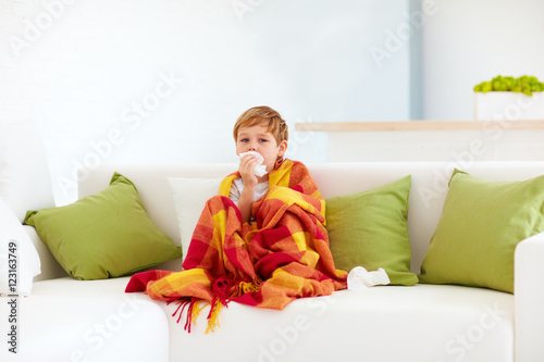 sick kid with runny nose and fever heat at home photo