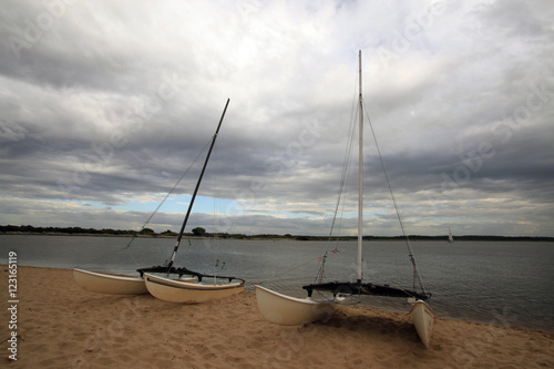 cloudy beach on Baltic sea with green catamarans