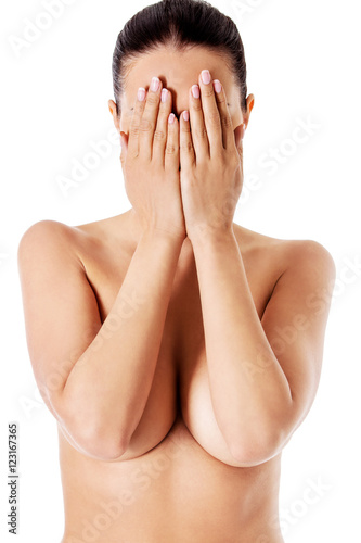 Young woman covering her face with her hands.