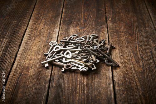 A Pile of Antique Keys on a weathered wooden background 