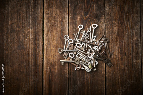 A Pile of Antique Keys on a weathered wooden background 