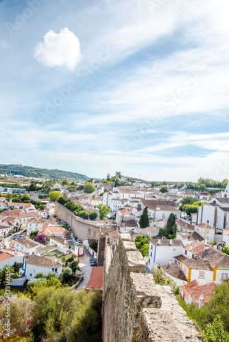 Obidos, Portugal : Cityscape of the town with medieval houses, wall and the Albarra tower. Obidos is a medieval town still inside castle walls, and very popular among tourists.