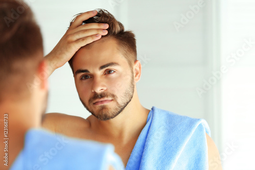 Handsome unshaven man looki...