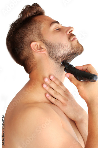 Handsome man shaving on lig...