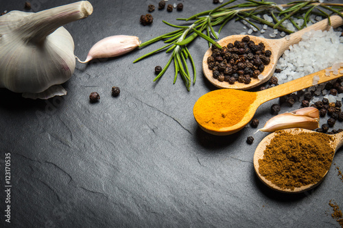 spices and herbs over black stone background  top view with copy space