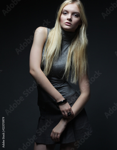 Portrait of beautiful young blonde girl in black dress. 
