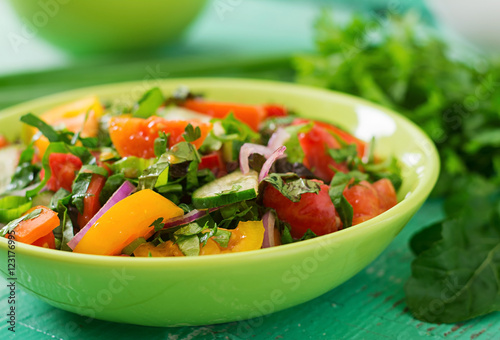 Fresh salad of tomatoes, cucumbers, peppers, arugula and red onion