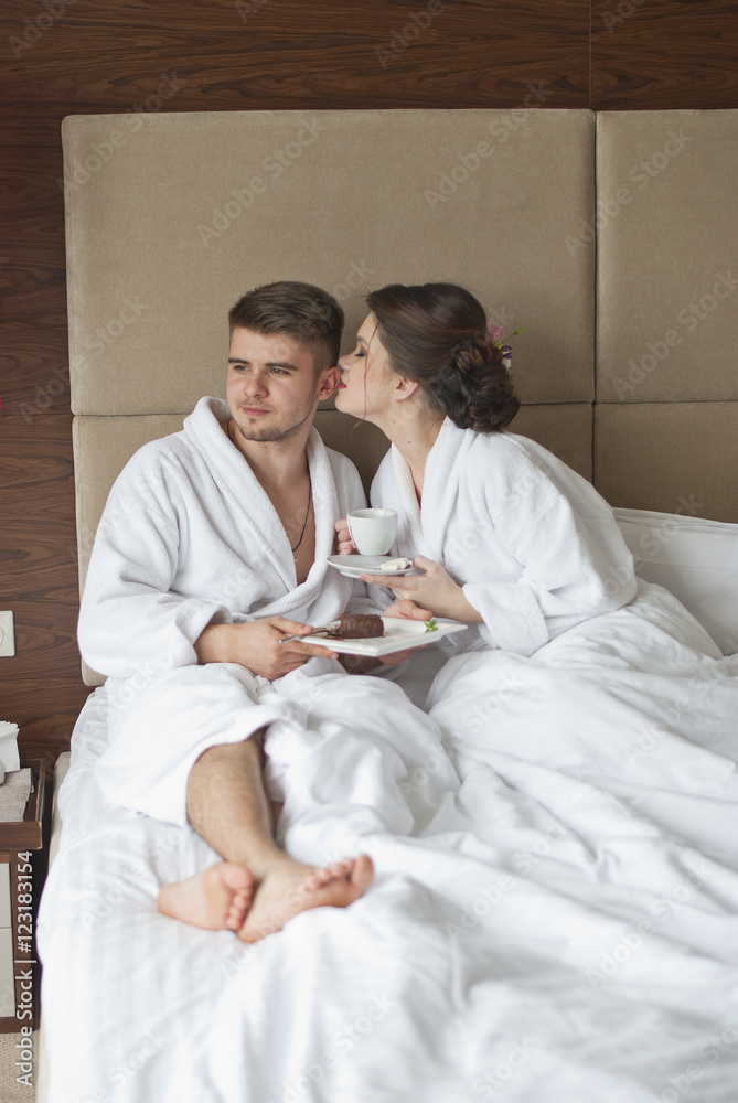 Beautiful young couple having breakfast in bed. Beautiful young couple having breakfast in bed.