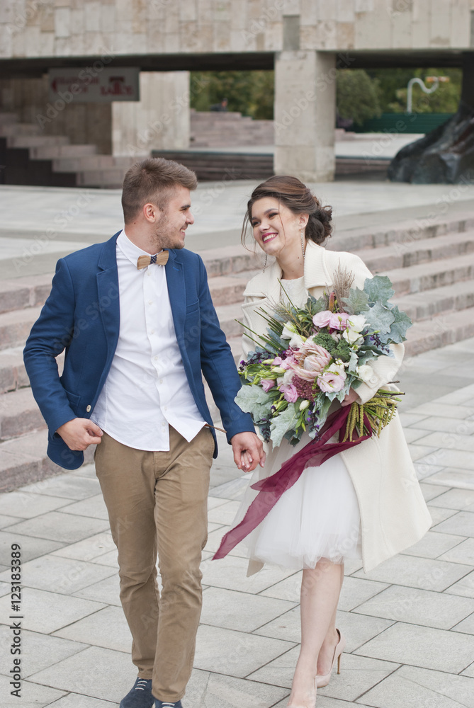 Just married loving couple in wedding dress and suit . Happy bride and groom walking running in the summer city. Romantic Married young family 