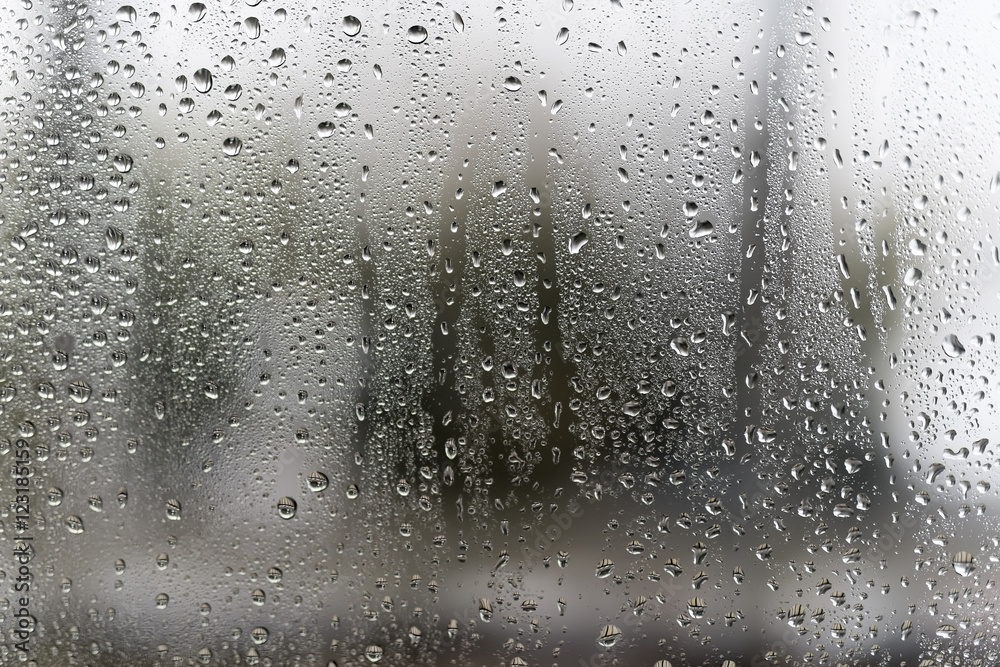 Drops fall rain on window glass - abstract blurred background