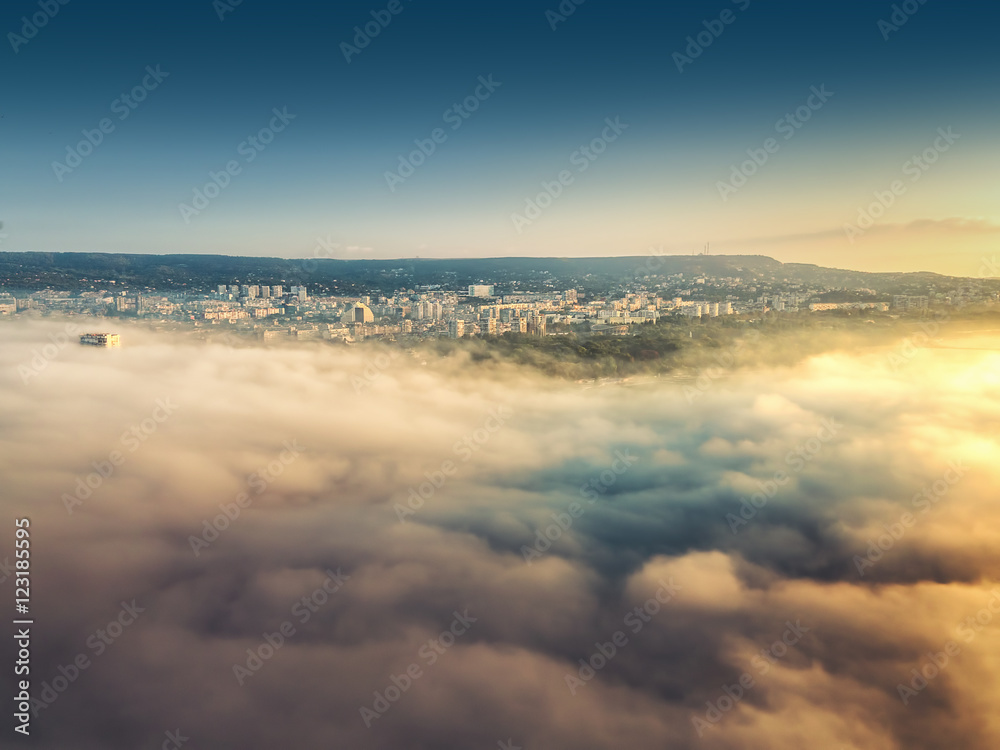 Flying above the clouds, view toward the city
