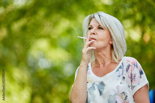 Alte Frau beim Rauchen einer Zigarette photo