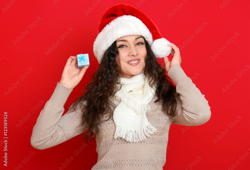 girl in santa hat portrait with little gift box posing on red color background, christmas holiday concept, happy and emotions girl in santa hat portrait with little gift box posing on red color background, christmas holiday concept, happy and emotions