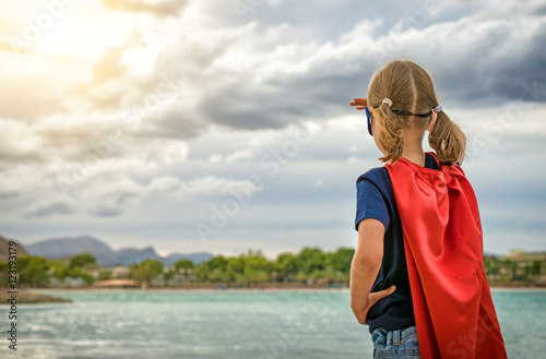Obraz na płótnie Superhero kid looking on the sunset.