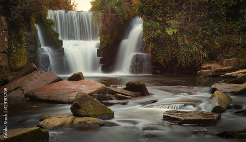 Fototapeta Naklejka Na Ścianę i Meble -  Autumn colours start to appear around the waterfalls at Penllergare woods, Swansea, UK