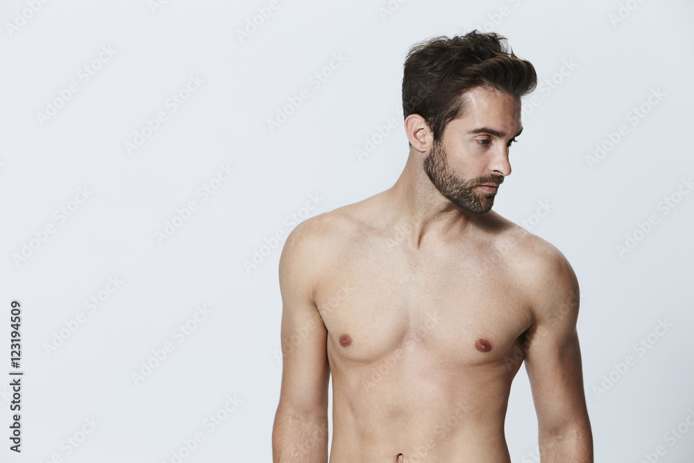 Shirtless dude looking away in studio