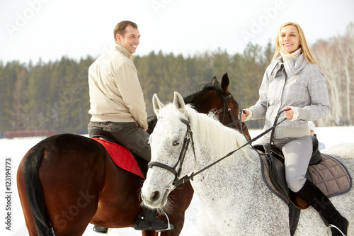 Portrait of happy family horseback riding in winter