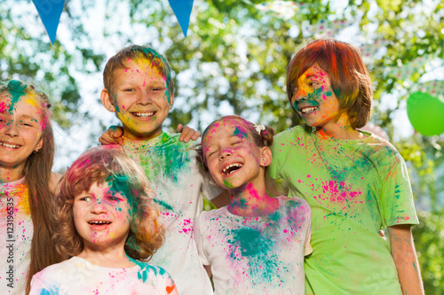 Happy laughing kids smeared with colored powder
