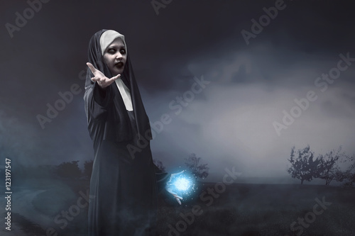 Devil asian nun with blue spell power in his hand