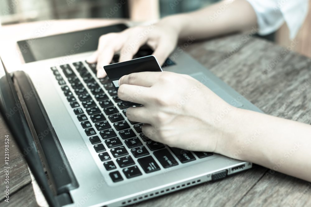 Hands women holding credit card and using laptop and tablet. Onl