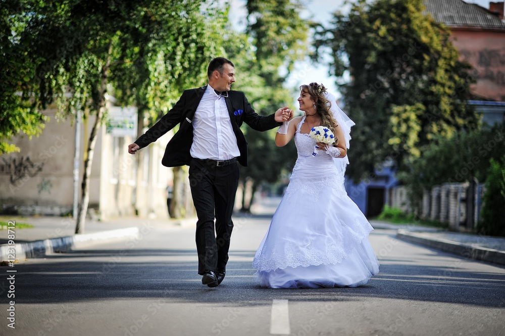 Wedding couple running and have fun on the road Wedding couple running and have fun on the road