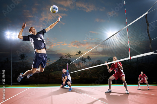 Professional volleyball players in action on the night court photo