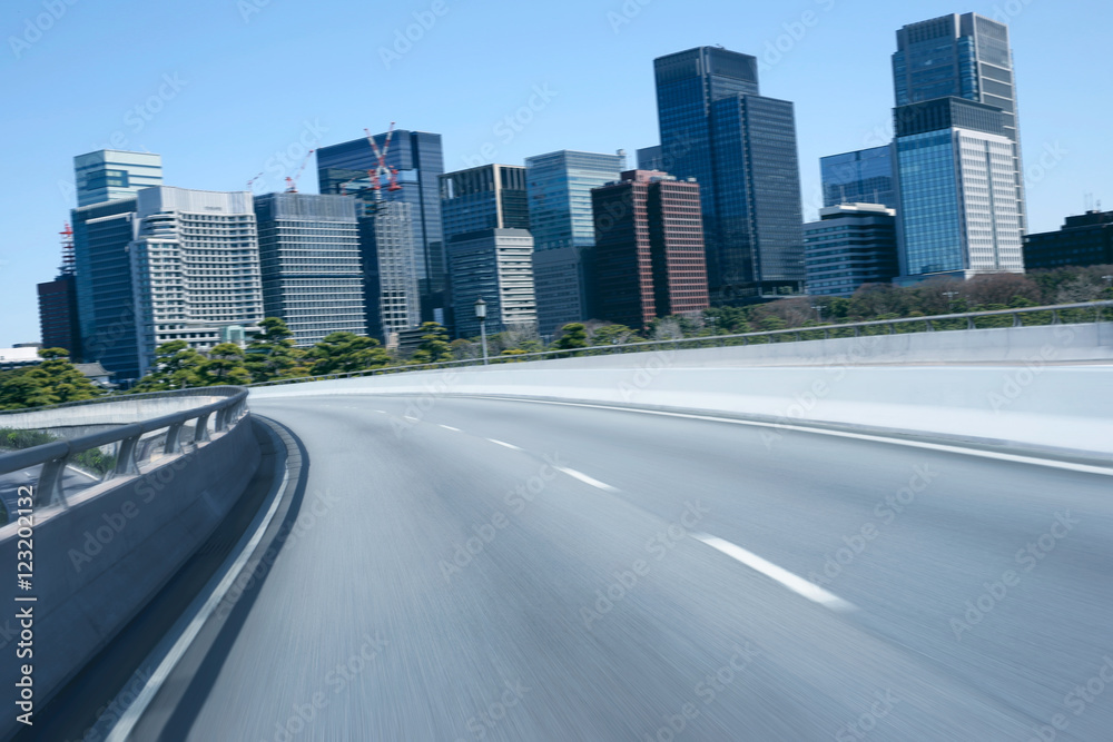 Highway overpass motion blur with city background . Highway overpass motion blur with city background .