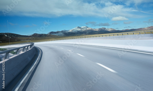 Highway overpass motion blur with mountain background .