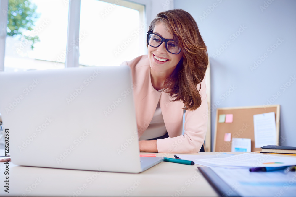 Happy woman working on her laptop at office Happy woman working on her laptop at office